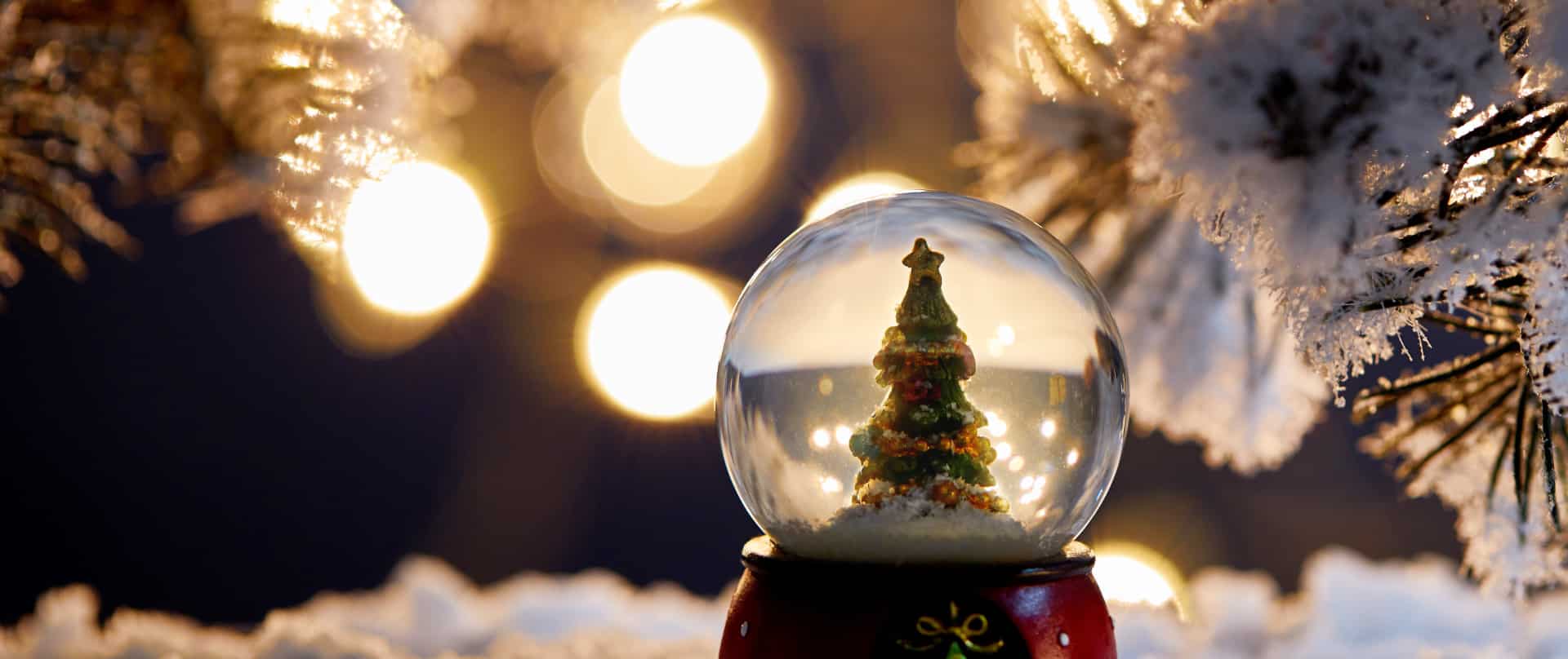 A glass Christmas snowball with Christmas tree inside.